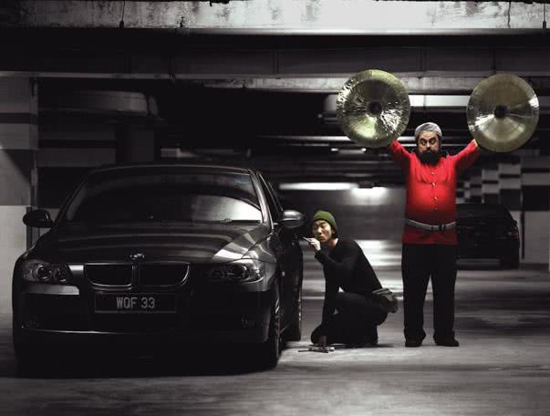 Another effective mean of protection is to equip your car with an alarm system a man holding a pair of gong beside a thief who is trying to steal a car