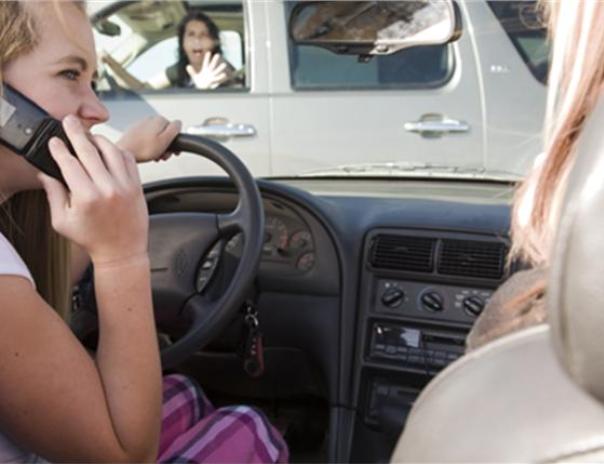 The law, however, does allow motorists to use a mobile phone to make an emergency call. A woman making a phone call while driving a car
