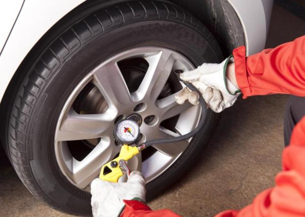 It's of paramount importance to inflate the tires correctly A car mechanic is inflating car tire
