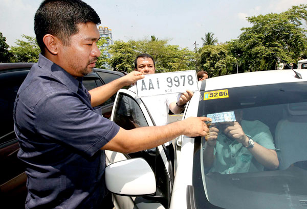 The initiative will make it more efficient for drivers and car owners to transact with the agency A man pointing finger towards a car number plate