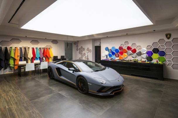The Lamborghini Aventador S features a matte Grigio Acheso exterior with matte orange accents angular front of the Lamborghini Aventador S at Goodwood