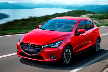 The beauty of the Mazda 2 is recognized by many even critics A red mazda 2 on the road