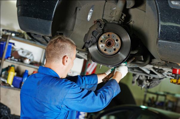Scheduled inspections and timely repairs will keep your car running efficiently A mechanic is inspecting a car