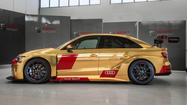 The car is covered by a “one-off” gold livery with red Audi Sport accents throughout the side Side view of the 100th Audi RS3 LMS