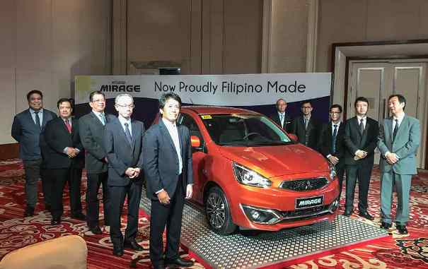 The first Mirage hatchback made by Filipino hands was presented last Thursday evening in a ceremony held the Solaire Resort and Casino in Parañaque City People standing around an orange Mirage hatchback