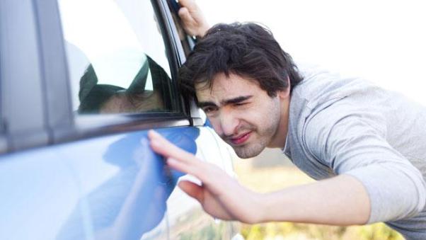 Un uomo che controlla un'auto