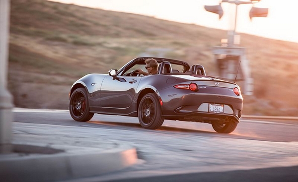 A gray Mazda Miata RF making its way through a city street