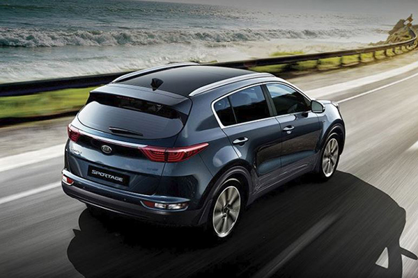 A shot of the rear of the Kia Sportage as it travels on a coastal road