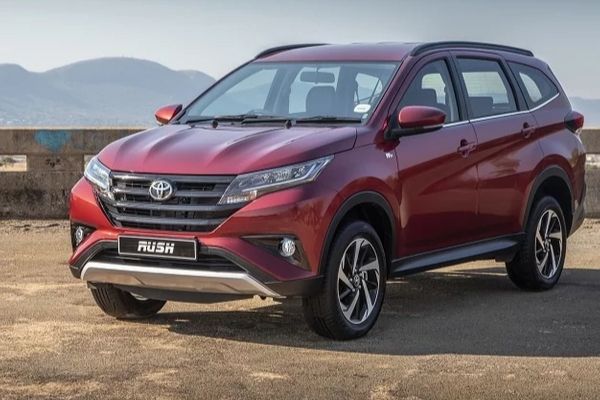 A picture of the 2019 Toyota Rush in red and parked on a seaside board-walk