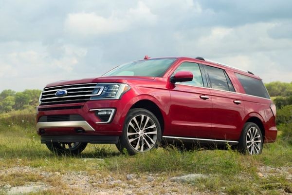 A picture of a red Ford Expedition climbing a hill