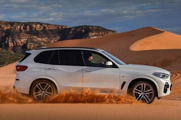 A picture of the 2020 BMW X5 driving on sand