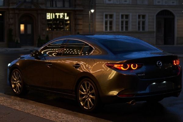 A picture of the Mazda3's rear while parked in the city