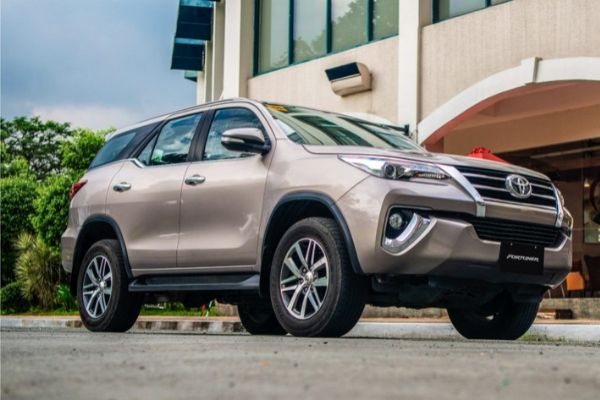 A picture of the Toyota Fortuner near a fancy building