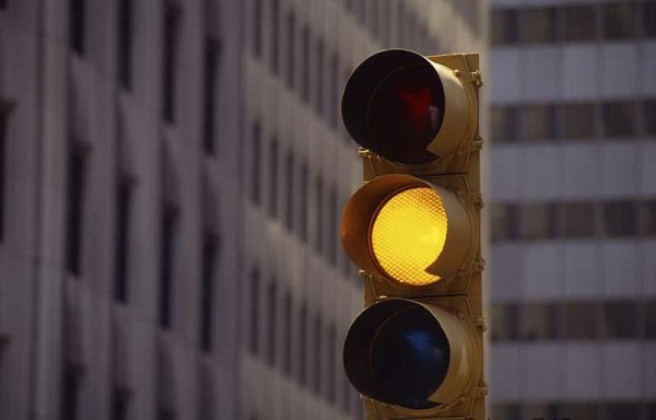 single bike rider on flashing red traffic signal