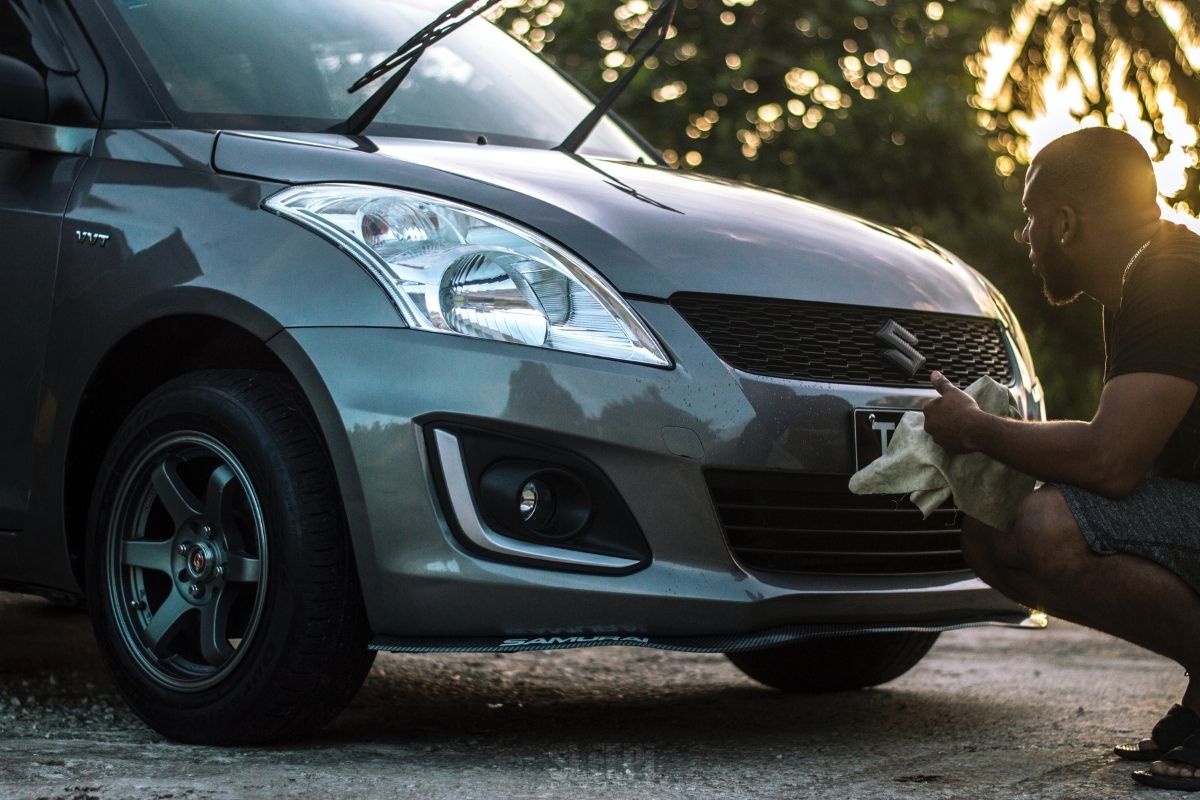 A man wiping a Suzuki Swift