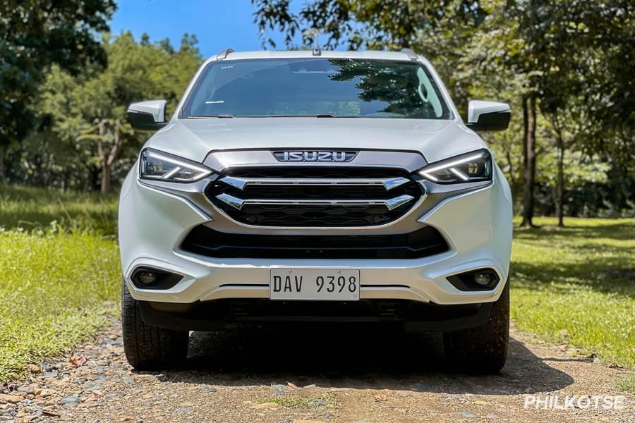 A head-on picture of the new Isuzu mu-X while it is parked in a grassy area.