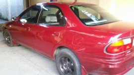 Red Mazda 323 1999 at 100000 km for sale