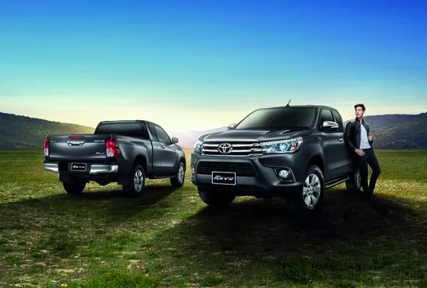 A boy with two models of the Toyota Hilux Revo 