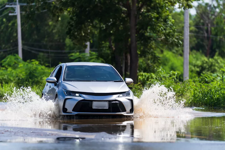 A car travelling over flooded road.