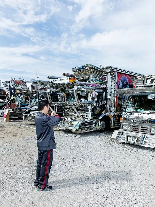 Driver in front of Dekotora trucks