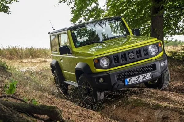 A picture of the Suzuki Jimny performing off-road in a wooded area.