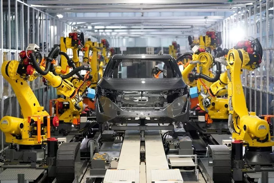 A picture of robot arms working on assembling a car