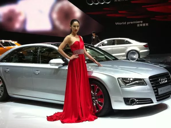 a promotion girl standing next to the Audi A8