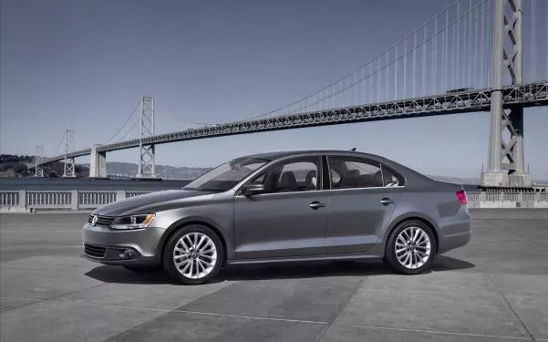 A Volkswagen Jetta in front of a bridge