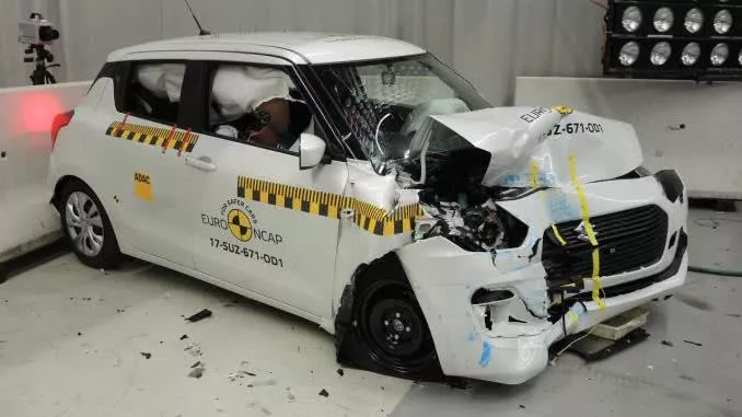 A broken white suzuki swift