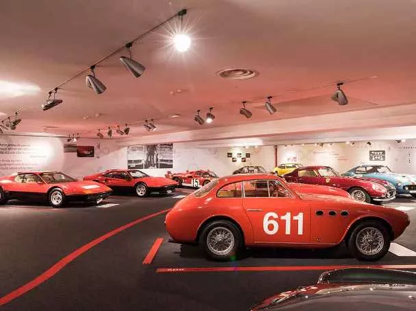 Red Ferrari cars on display in the museum