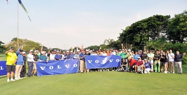 People posing for a group photo in the middle of a green golf course
