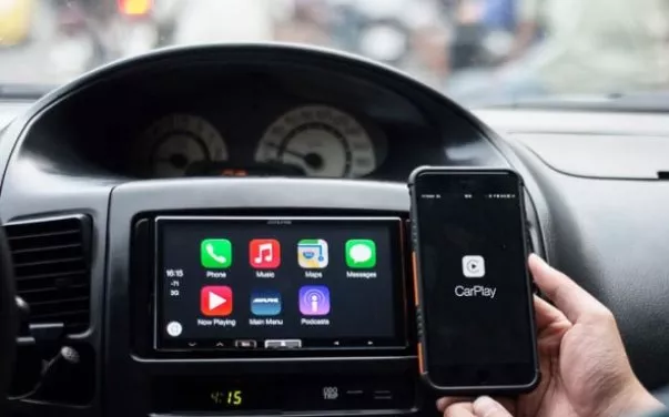 A phone with Apple Carplay in front of a dashboard