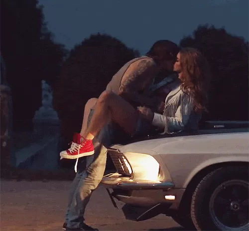 a couple making out on a car hood