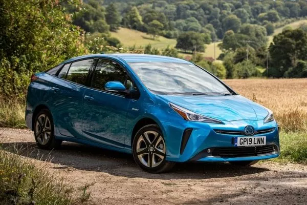 A picture of a blue Toyota Pruis in the countryside