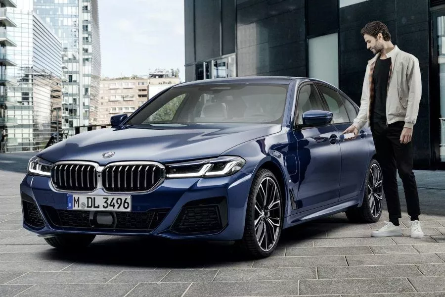 A picture of a person unlocking a BMW using his phone.