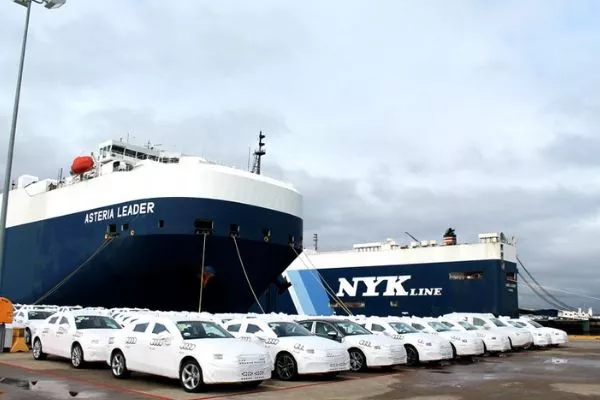 A picture brand new cars about to be loaded into a car carrier ship