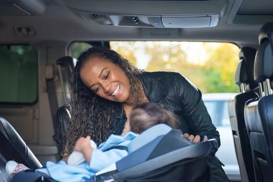 Mother seating child in a child seat