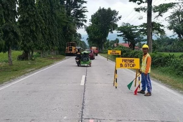 The widening of the Lake Sebu road is a joint effort by the DPWH and the DOT Men diverting traffic on the Lake Sebu road construction site