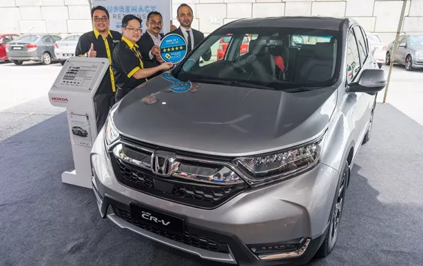 NCAP and Honda officers standing beside a silver Honda CR-V