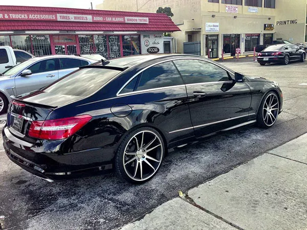 A parked mercedes benz coupe with very dark tint. 