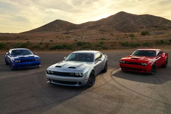 A picture of several Dodge Challengers parked on the road