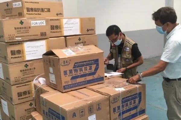 A picture of DOH employee in a warehouse receiving donated surgical masks