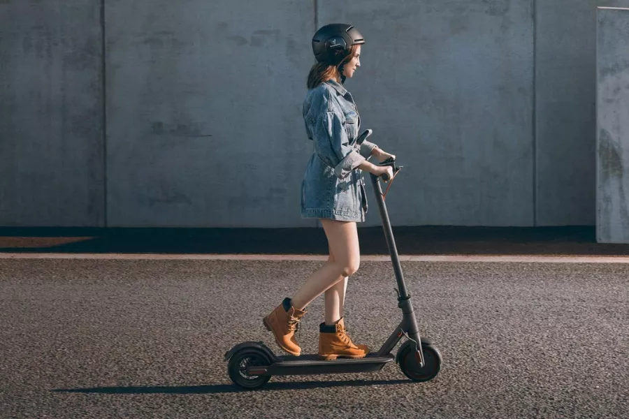 A picture of a woman riding an e-scooter