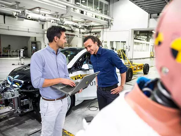 two men discussing over a laptop in an BMW manufacture