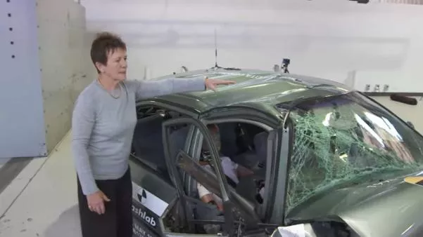 The 1998 Corolla model suffered “catastrophic structural failure” A woman standing next to a seriously damaged 1998 Corolla