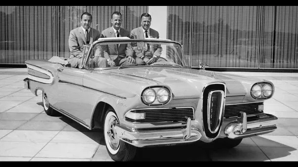 Three men sitting in a silver Ford Edsel