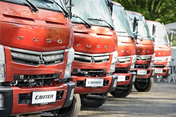 A picture of canter trucks lined up in a parking area