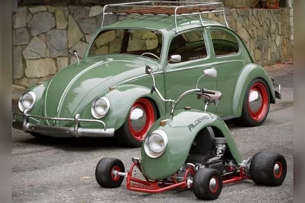 The unique go-kart next to a classic VW Beetle