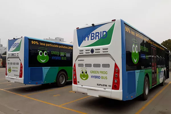 A picture of two Green Frog hybrid buses parked in their garage.