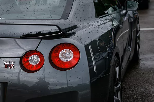 A rear view of a Nissan GT-R parked in the rain.